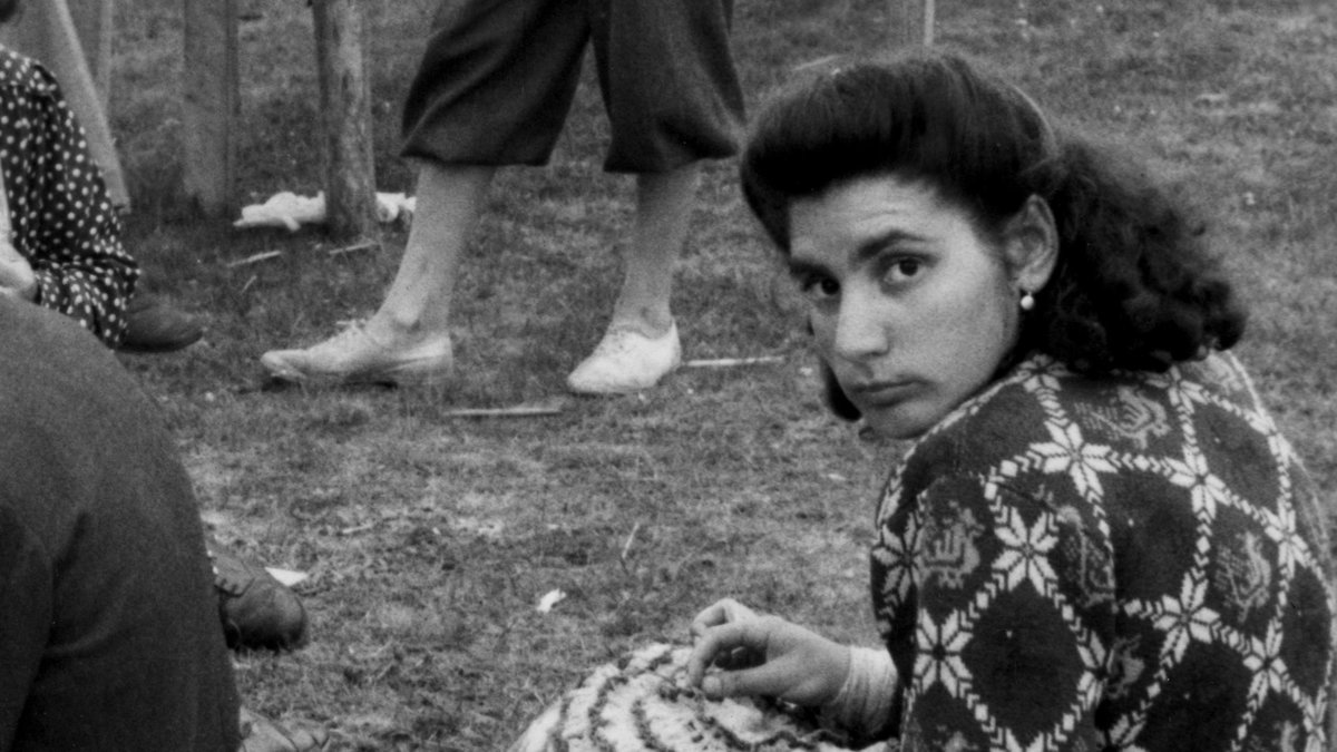 Den unga kvinnan virkar minnessaker till försäljning på Kiviks marknad i juli 1947.